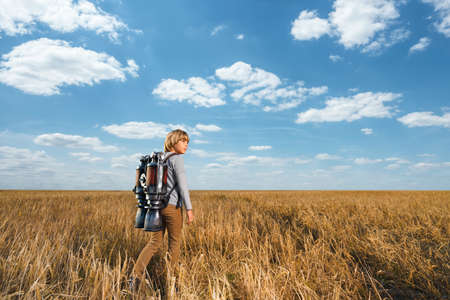 Little boy with a backpack in fieldの写真素材
