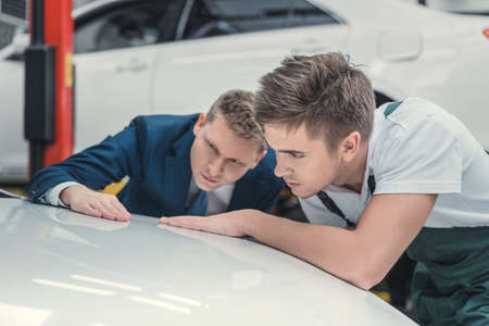 Young people with car indoorsの写真素材