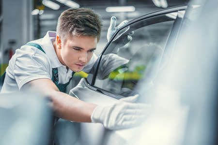 Young man washing car in serviceの写真素材