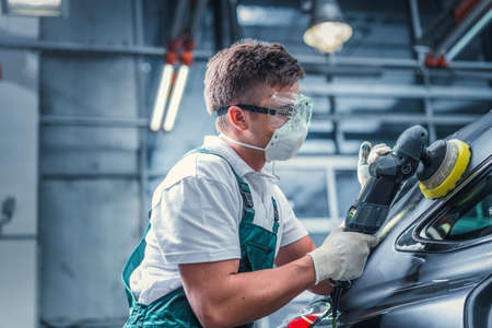 Young man polishing car in service