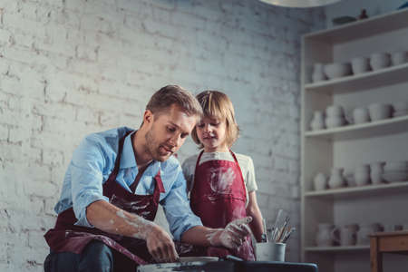Dad and son in potteryの写真素材