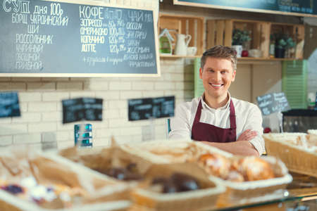 Smiling man in bakeryの写真素材
