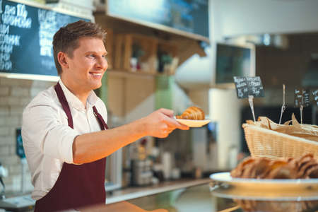 Smiling bakery in uniformの写真素材