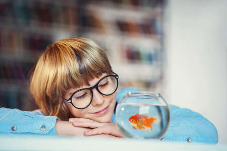Little boy with goldfishin library
