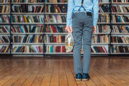 Little child with goldfish in libraryの写真素材