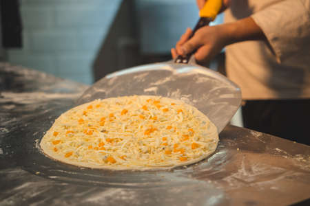 Chef preparing pizza indoorsの写真素材