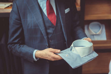 Man is holding a shirtの写真素材