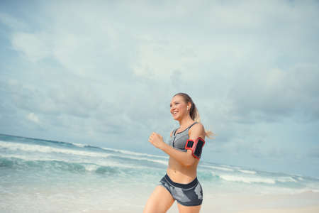 Smiling girl running on beachの写真素材