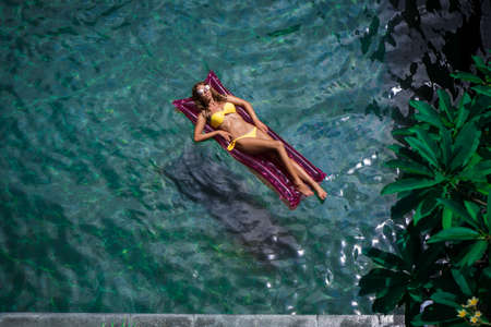 Young woman in the poolの写真素材