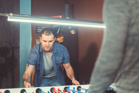 Young man playing football indoorsの写真素材
