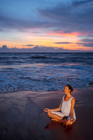 Young woman doing yoga on the beachの写真素材