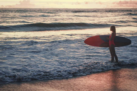Young woman with a surfboard outdoorsの写真素材