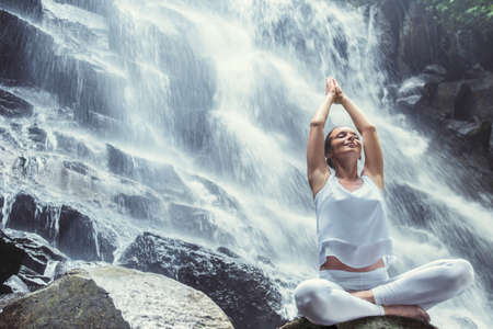 Happy woman doing yoga outdoorsの写真素材