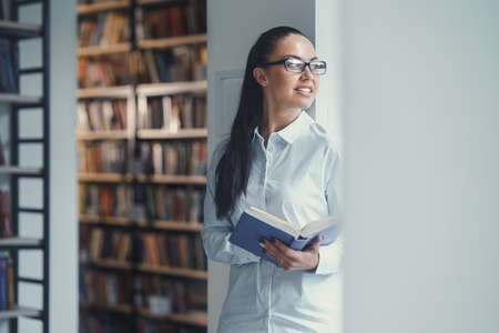 Smiling young girl in a libraryの写真素材