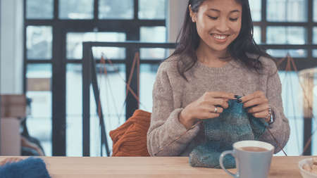 Smiling girl knitting in studioの写真素材