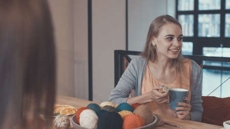Smiling girl at the table in studioの写真素材