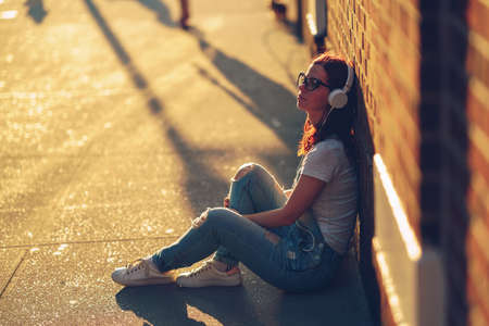 Young girl with a headphones outdoors