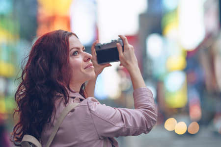 Young girl with a camera on the streetの写真素材