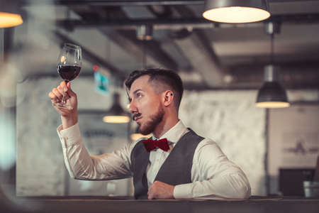 Young sommelier with a glass of wineの写真素材