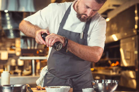 Young cook preparing in the kitchenの写真素材