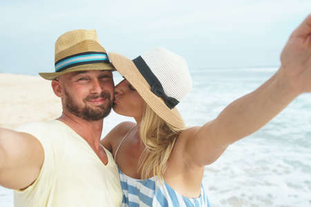 Kissing couple makes selfie outdoorsの写真素材