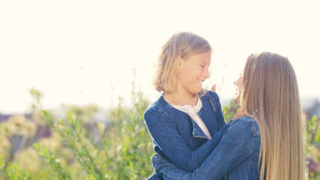 Smiling mother and daughter in summer outdoorsの写真素材