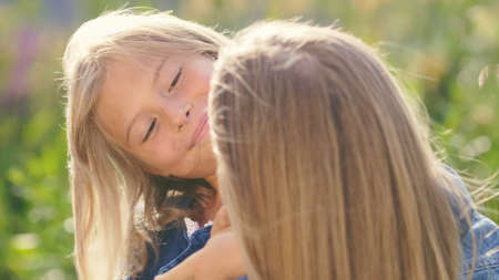 Happy little girl with mother in summerの写真素材