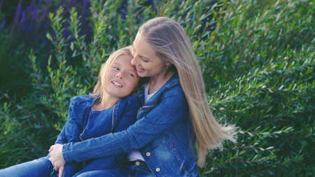 Smiling mom ahd daughter in the park on vacationの写真素材