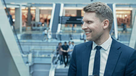 Young happy businessman in a suit indoorsの写真素材