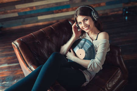 Smiling young girl listening to music indoors
