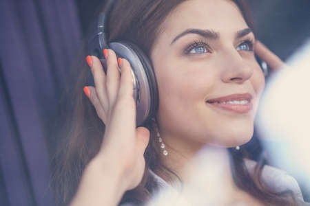 Smiling young girl listening to music on headphonesの写真素材