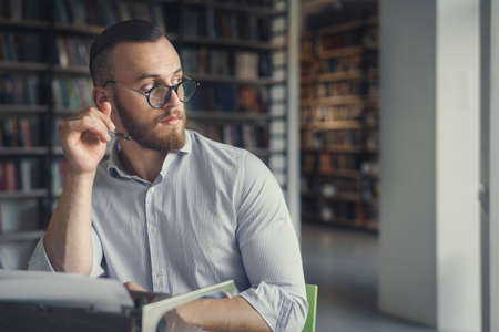 Young man at work in the libraryの写真素材