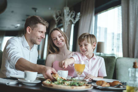 Young family having lunch in a restaurantの写真素材