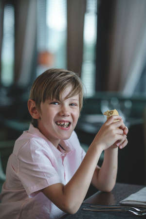 Smiling boy with a pie in a restaurantの写真素材