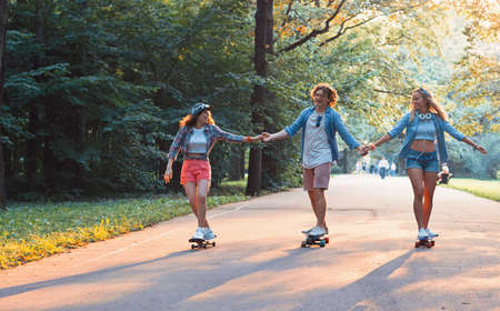 Young happy skaters in the park on vacation