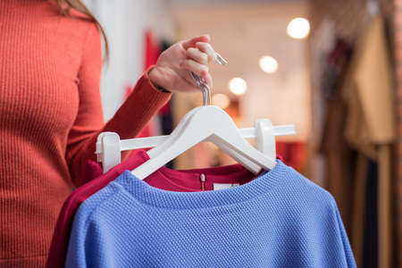 Young girl with clothes in the storeの写真素材