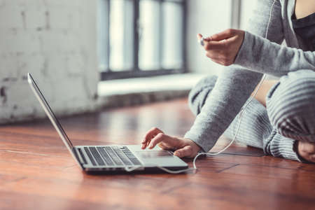 Young woman with laptop in the loftの写真素材