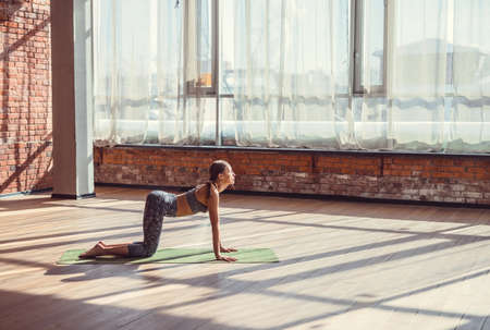 Young girl practicing yoga in the sunlight