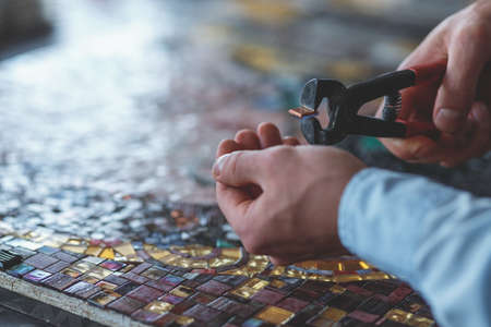 Mens hands cutting mosaicの写真素材