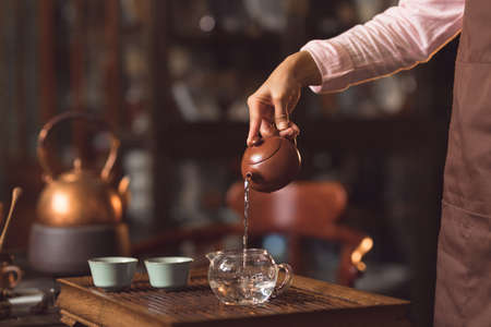 Womens hands pouring tea indoorsの写真素材