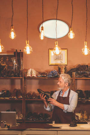 An elderly shoemaker with a shoeの写真素材