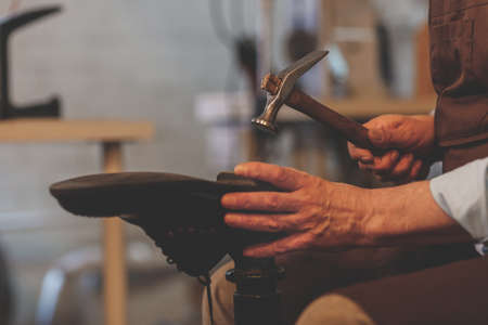 An elderly shoemaker at work close-upの写真素材