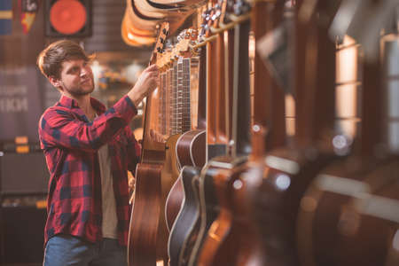 Young musician choosing a guitarの写真素材