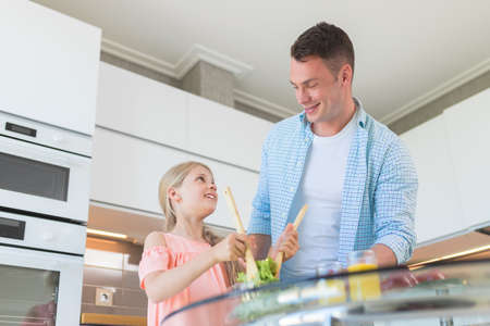 Young father with a little daughter in the kitchenの写真素材