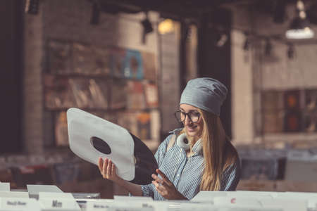 An attractive girl with a vinyl record indoorsの写真素材