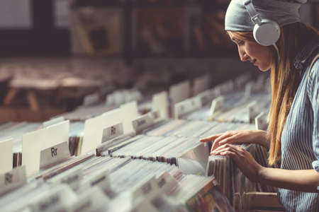 Young girl with headphones browsing vinyl recordsの写真素材