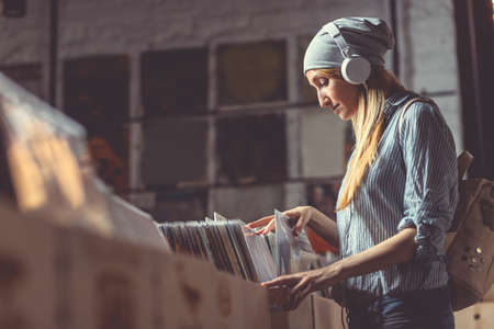 Young woman with headphones browsing vinyl recordsの写真素材