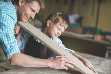 Smiling father and son in the carpentryの写真素材