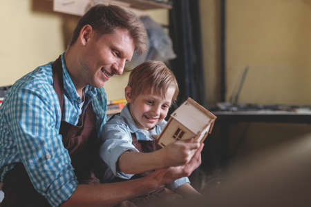 Father and son with a wooden houseの写真素材