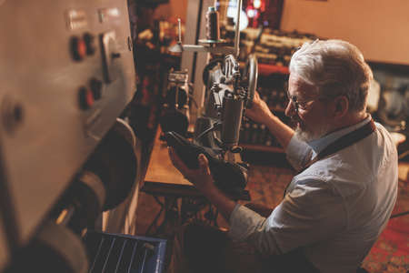 An elderly professional in a workshopの写真素材